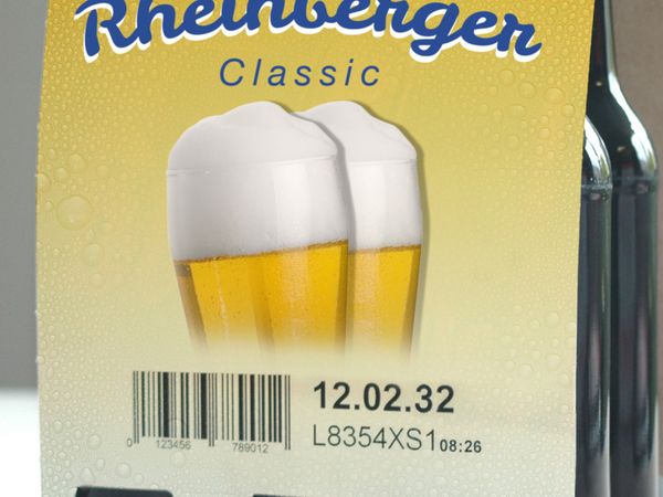 Industrial inkjet coding with BBD and barcode on yellow cardboard packaging