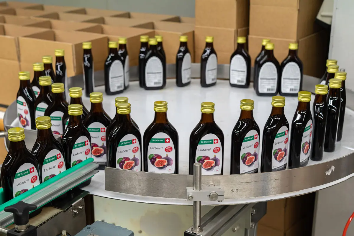 Front and back side labelling of flat glass bottles for beverages